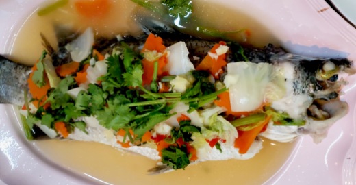 A large steamed fish with common Thai Veggies